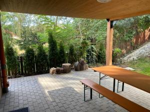 eine Terrasse mit einem Holztisch und einer Bank in der Unterkunft SKH L , 1 apartment, 2 bedrooms in Praid
