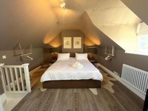 a bedroom with a large bed in a attic at Cosy two bed townhouse in Centre of C.Norton in Chipping Norton