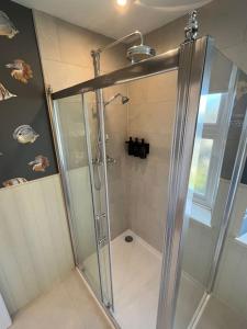 a shower with a glass door in a bathroom at Cosy two bed townhouse in Centre of C.Norton in Chipping Norton