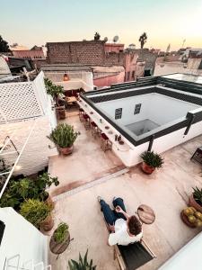 due persone sedute su un tetto di un edificio di Riad Darsahalia a Marrakech