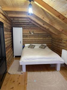 um quarto com uma cama num chalé de madeira em AirGreen Cabană 