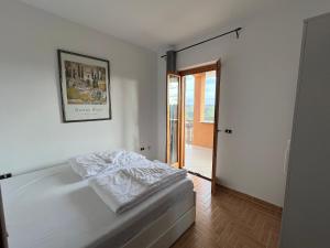 1 dormitorio con 1 cama y puerta a un balcón en Villa di Mergo - Privatunterkunft, Ponzano Romano en Ponzano Romano
