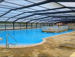a large swimming pool with blue water in a building at Le Kraken in Aureilhan