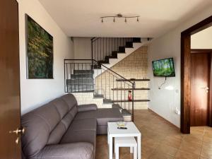 a living room with a couch and a staircase at Villa di Mergo - Privatunterkunft, Ponzano Romano in Ponzano Romano