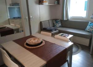 a living room with a table and a couch at Le Kraken in Aureilhan