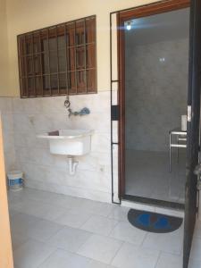 a bathroom with a sink and a shower at Orange House Itaipuaçu in Maricá