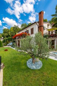 a tree in a yard in front of a house at Apartment Srok, Relax in Kastav