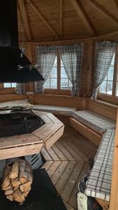 an inside view of a cabin with a stove and windows at Skogstad Ferie og fritid in Tromsø
