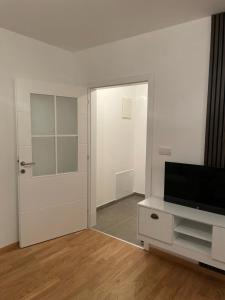 un salon vide avec une télévision et une porte dans l'établissement Apartman Jovanov Dvor, à Bijeljina