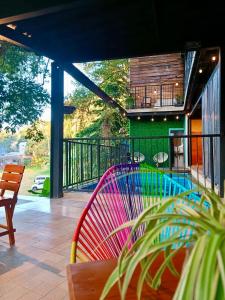 a colorful bench on a balcony with a pool at Coffee House Minca in Minca