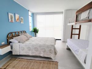 um quarto com 2 camas e uma parede azul em HERMOSA CASA CON PISCINA FRENTE AL MAR - PRIMERA FILA em Chincha Baja