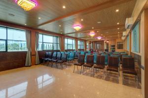 a conference room with blue chairs and windows at Hotel Flysky Rooms & Banquets in Navi Mumbai