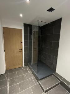 a bathroom with a shower with a glass door at Upsall Warren Cottage in Middlesbrough