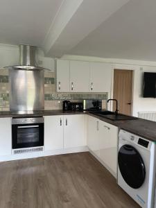 a kitchen with white cabinets and a stove top oven at Upsall Warren Cottage in Middlesbrough