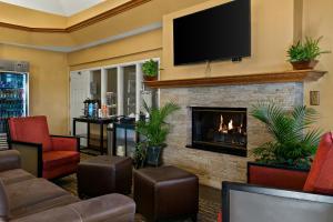 vestíbulo con chimenea y TV de pantalla plana en Comfort Suites, en Saginaw