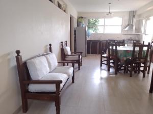een woonkamer met stoelen en een tafel en een keuken bij CASA EN VALERIA DEL MAR Y PLAYA in Valeria del Mar