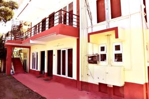 a red and white building with a red floor at Mel Rose Cottage Ooty in Ooty