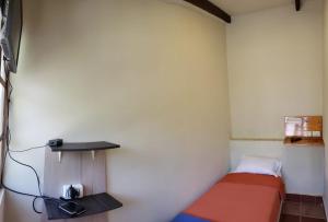 um pequeno quarto com uma cama e uma prateleira em Villa Etelvina em Torotoro