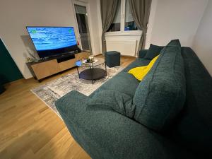 a living room with a green couch and a television at Apartman Besta in Banja Luka