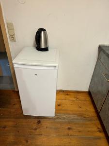 a tea kettle sitting on top of a white refrigerator at Nicole in Pfaffenhofen an der Glonn