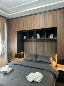 Mans lux 8 Apartman في زلاتيبور: غرفة نوم بسرير كبير عليها منشفتين