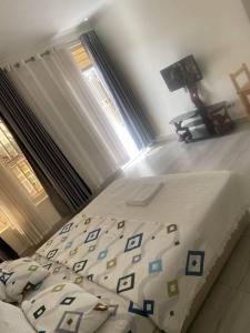 1 dormitorio con 1 cama con sábanas azules y blancas en ADRIEL HOMES KIGALi en Kigali