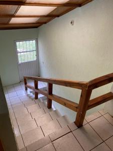 un banco de madera en una habitación con ventana en Departamento céntrico casa Paulora, en Hidalgo del Parral