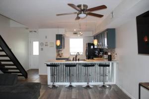 a kitchen with a ceiling fan and a bar with stools at Downtown Condo in Little Rock