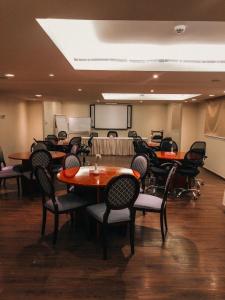 فندق فيلي Filly Hotel في حائل: قاعة اجتماعات مع طاولات وكراسي وطاولة بيضاء