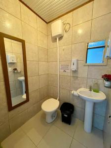 La salle de bains est pourvue de toilettes et d'un lavabo. dans l'établissement Pousada Recanto do Norte, à Florianópolis
