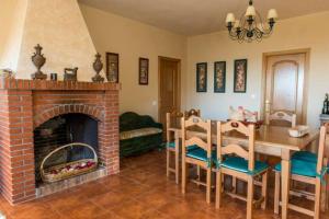a living room with a fireplace and a table and chairs at Casa Rural La Milagrosa en Córdoba in Córdoba