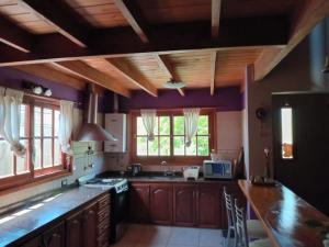 a kitchen with purple walls and wooden cabinets and a counter at Miramar in Miramar