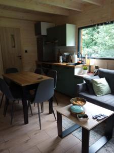 cocina y sala de estar con mesa y sofá en Dom nad wodospadem en Kletno