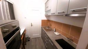 a small kitchen with white cabinets and a sink at Mikesh in Virovitica