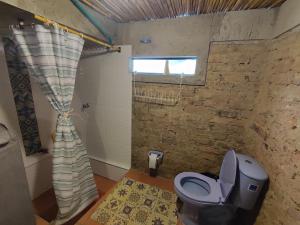 a bathroom with a toilet and a shower with a window at El Caña Bravo Posada, Alojamiento de Descanso in Duitama +36 photos