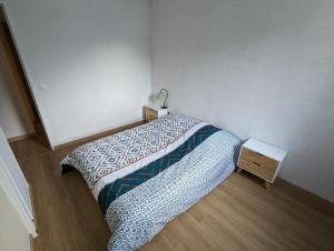 ein kleines Schlafzimmer mit einem Bett und einem Nachttisch in der Unterkunft Central spacious flat with private parking in Chamonix-Mont-Blanc