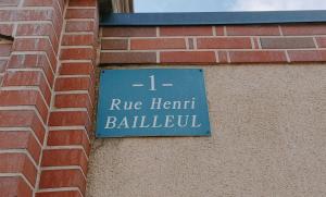 un panneau sur le côté d'un bâtiment en briques dans l'établissement Demeure en Seine - Gîtes et chambres d'hôte en bord de Seine, à Caudebec-en-Caux