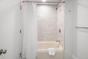 y baño blanco con bañera y ducha. en Charlesgate Suites, en Boston