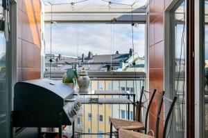 balcón con vistas a la ciudad desde una ventana en Modern flat in the citycenter Helsinki, en Helsinki