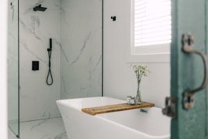a bathroom with a bath tub and a shower at The Old Homestead - Gorgeous backyard right in The Heart of Picton in Picton +41 photos
