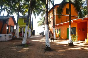 eine Gruppe von Palmen neben einem Gebäude in der Unterkunft KonkanParadise,Hotel Malvan Beach in Malvan
