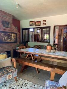 uma sala de estar com uma mesa de madeira e bancos em Residência familiar com piscina e área de lazer em São Gabriel