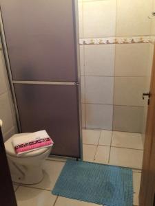 uma casa de banho com um chuveiro, um WC e um tapete em Residência familiar com piscina e área de lazer em São Gabriel