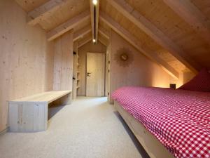 a room with a bed and a bench in a attic at Ferienhaus Königsdorf - Urlaub im Tölzer Land in Königsdorf