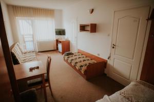 Una habitación de hotel con una cama, una mesa y un escritorio. en Wiking, en Jastrzębia Góra