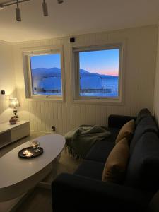 un soggiorno con divano e 2 finestre di Apartment with a unique view, center of Kvaløya a Tromsø