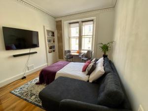 a bedroom with a large bed and a couch at Traveller Award Winner 2023 - Edinburgh Apartment with 3 Beds in Edinburgh