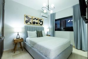 a bedroom with a large bed and a window at Modern 2BR in La Trinitaria Sti No in Santiago de los Caballeros +27 photos
