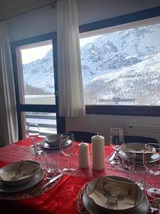 a table with a red table cloth with wine glasses at Ski paradise - Cielo alto Cervinia in Breuil-Cervinia