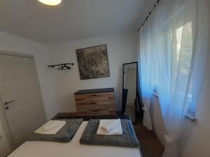 sypialnia z 2 łóżkami, komodą i oknem w obiekcie Holiday House emjalemi w Puli